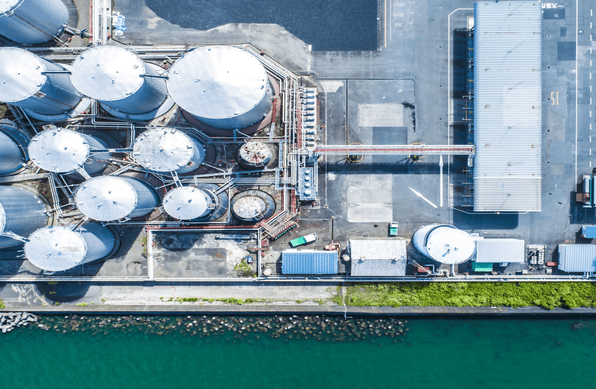 Aerial view of fuel storage tanks and industrial infrastructure by the water